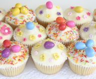 lemon sponge muffins - Lemon sponge cakes flavoured with freshly grated lemon zest, coated with lemon butter icing made with freshly squeezed lemon juice, and decorated with hand cut flowers, sprinkles and coloured Easter eggs.